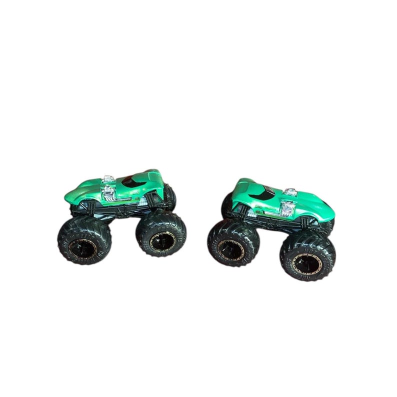 May include: Two green monster trucks with black tires and silver engine details are displayed against a white background. The trucks have a sleek, aerodynamic design and large, rugged tires, perfect for off-road adventures.