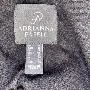 May include: A black tag with white text that reads "R ADRIANNA PAPELL" and size information for US, CAN, UK, EU/FR, DE, ES, IT, and AUS. The tag also says "MADE IN CHINA".