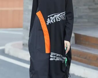 Vestido tipo camiseta negra con gráficos y detalles en naranja y verde, talla pequeña