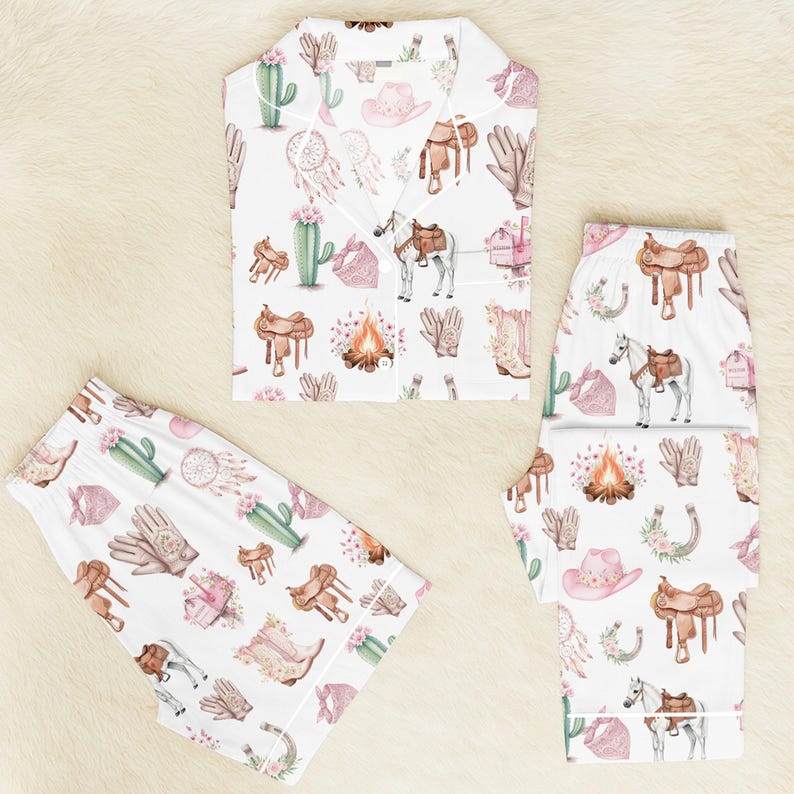 Puede incluir: Conjunto de pijama blanco con un estampado repetido de ilustraciones tem&aacute;ticas de vaqueros. El estampado incluye cactus, sombreros de vaquero, sillas de montar, caballos y botas en tonos rosas, marrones y verdes. El conjunto incluye una camisa con botones y pantalones.