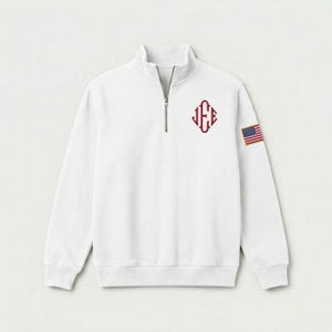 May include: A white long-sleeve quarter-zip pullover sweatshirt featuring a maroon monogram with the letters J, E, and E arranged in a diamond shape on the left chest and a small rectangular American flag patch on the upper left sleeve.