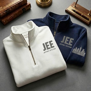 May include: Two fleece pullovers, one white and one navy blue, with a quarter-zip closure and the text "JEE JEFFREY EPSTEIN" printed on the chest. The navy blue pullover has a skyline graphic on the sleeve.
