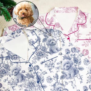 Könnte beinhalten: Weißes Pyjama-Set mit blauem Blumen- und Pudel-Print. Das Set besteht aus einem Hemd mit Knöpfen und einer Tasche sowie einer passenden Hose. Ein individuelles Foto eines Hundes befindet sich in einem Kreis über dem Pyjama. Der Text "Custom photo" ist ebenfalls im Bild.
