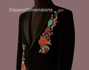 May include: Black blazer with colorful floral embroidery on the lapel and sleeve. The embroidery features orange, red, green, and blue flowers and leaves. The text "DapperDimensions" is visible on the image.