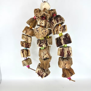 May include: A wooden bird toy with multiple pieces of wood strung together with colourful beads. The toy is designed for birds to chew and play with.