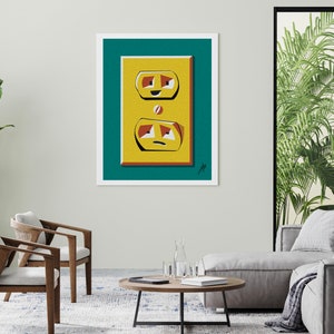 May include: A teal blue framed print of a yellow electrical outlet with a cartoon face. The outlet has two slots and a round ground prong. The outlet is smiling in the top slot and frowning in the bottom slot.