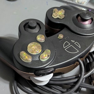 Puede incluir: Una taza de cerámica blanca con un asa negra y el texto "But First, Coffee" en negro, con una fuente de estilo manuscrito. La taza está sobre una superficie blanca.