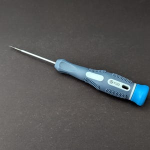 May include: A precision screwdriver with a silver tip and a blue and gray handle. The handle has a textured grip for better control. The screwdriver is designed for detailed work and repairs.
