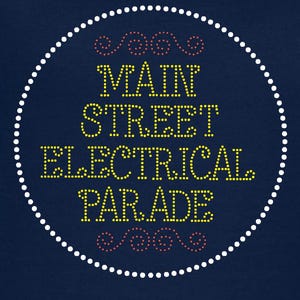 May include: Navy blue V-neck t-shirt with the text "MAIN STREET ELECTRICAL PARADE" in yellow and pink rhinestones, encircled by a dotted white line. The shirt is a solid color and has a simple, classic design.