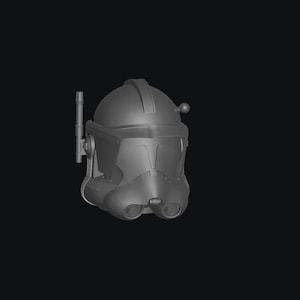 May include: A gray, detailed helmet with a rounded top, visor, and side antenna. The helmet has a smooth, matte finish and is set against a black background. The design includes features like a chin strap and a small, spherical detail on the side.