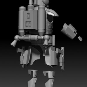Puede incluir: Un kit de modelo de pl&aacute;stico gris de un personaje de Star Wars con un jetpack y un bl&aacute;ster. El modelo est&aacute; desmontado y las piezas est&aacute;n dispuestas sobre una superficie gris.