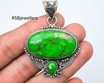 May include: A silver pendant with a green turquoise stone. The pendant has an ornate design with a bail at the top for attaching a chain.