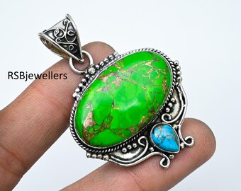 May include: A silver pendant with a green and gold turquoise stone and a smaller blue turquoise stone. The pendant has an intricate design with swirls and beads.