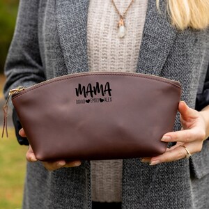 May include: A brown leather zippered pouch with the text "MAMA DAVID EMILY ALEX" and three small hearts.