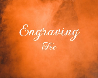 May include: An orange background with white text that reads "Engraving Fee". The text is in a cursive font. The background has a smoky, hazy appearance.