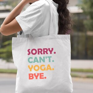 Puede incluir: Bolsa de tela blanca de lona con el texto "SORRY. CAN'T. YOGA. BYE." en letras de colores.