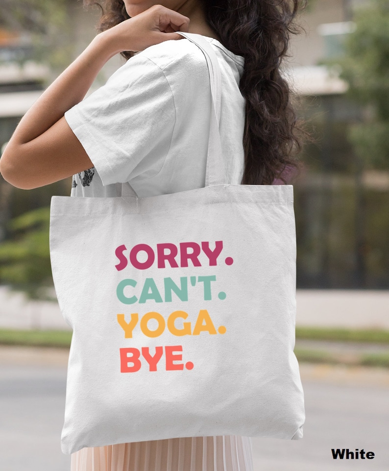 Puede incluir: Bolsa de tela blanca de lona con el texto "SORRY. CAN'T. YOGA. BYE." en letras de colores.