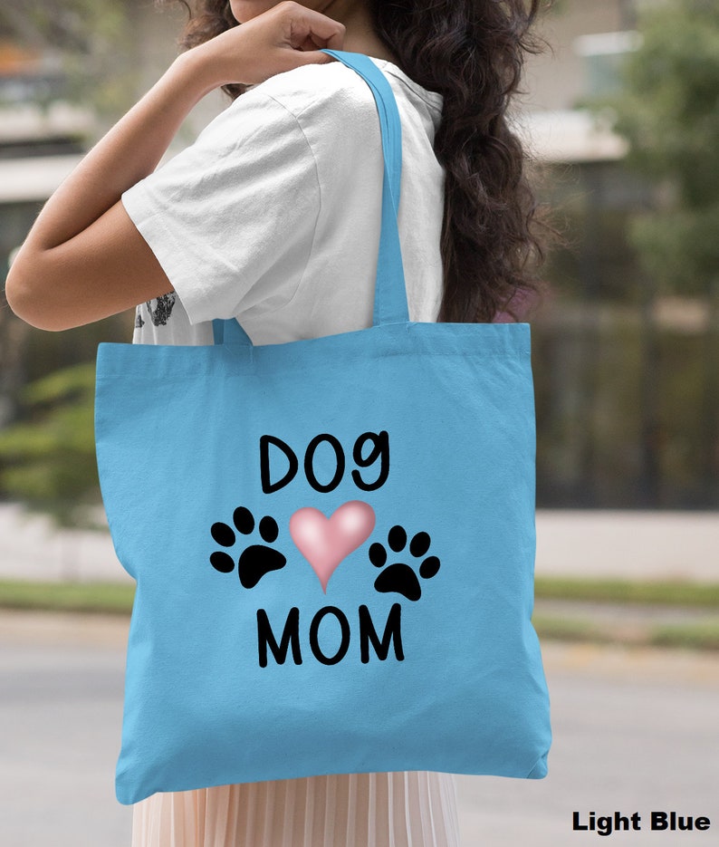 May include: Light blue tote bag with the text "Dog Mom" and a pink heart with paw prints on either side.