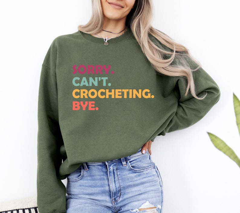May include: A green sweatshirt with the text "Sorry. Can't. Crocheting. Bye." in colorful letters.