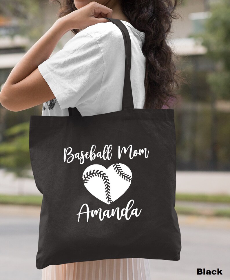 May include: Black canvas tote bag with white text that reads "Baseball Mom Amanda" and a white baseball in a heart shape.