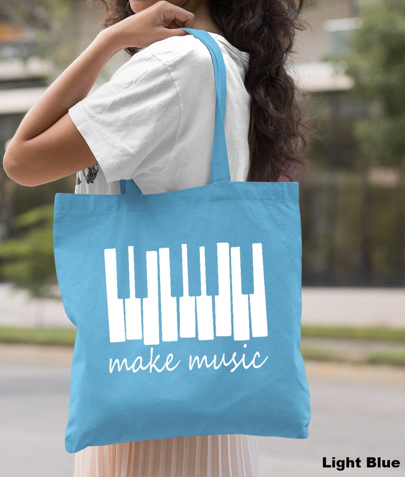 May include: Light blue canvas tote bag with white piano keys and the text "make music".