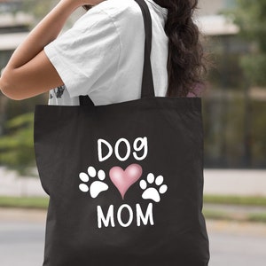May include: Black canvas tote bag with white text that reads "Dog Mom" and a pink heart with white paw prints on either side.