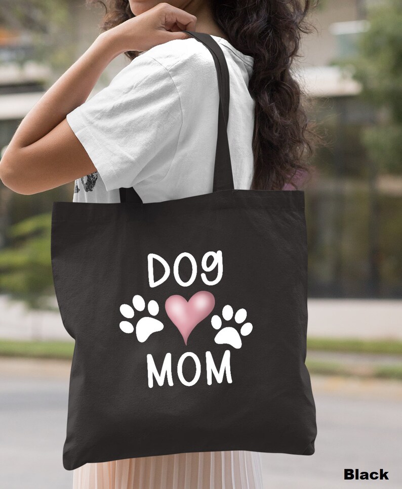 May include: Black canvas tote bag with white text that reads "Dog Mom" and a pink heart with white paw prints on either side.