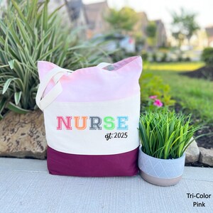 May include: A pink and maroon tote bag with the word "NURSE" in rainbow colours and the text "est. 2025" underneath.