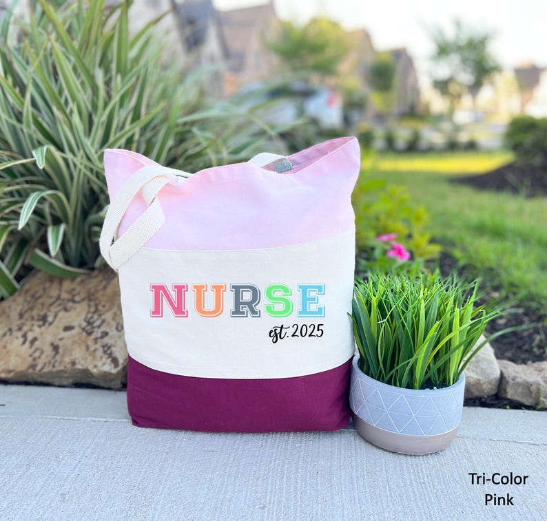 May include: A pink and maroon tote bag with the word "NURSE" in rainbow colours and the text "est. 2025" underneath.