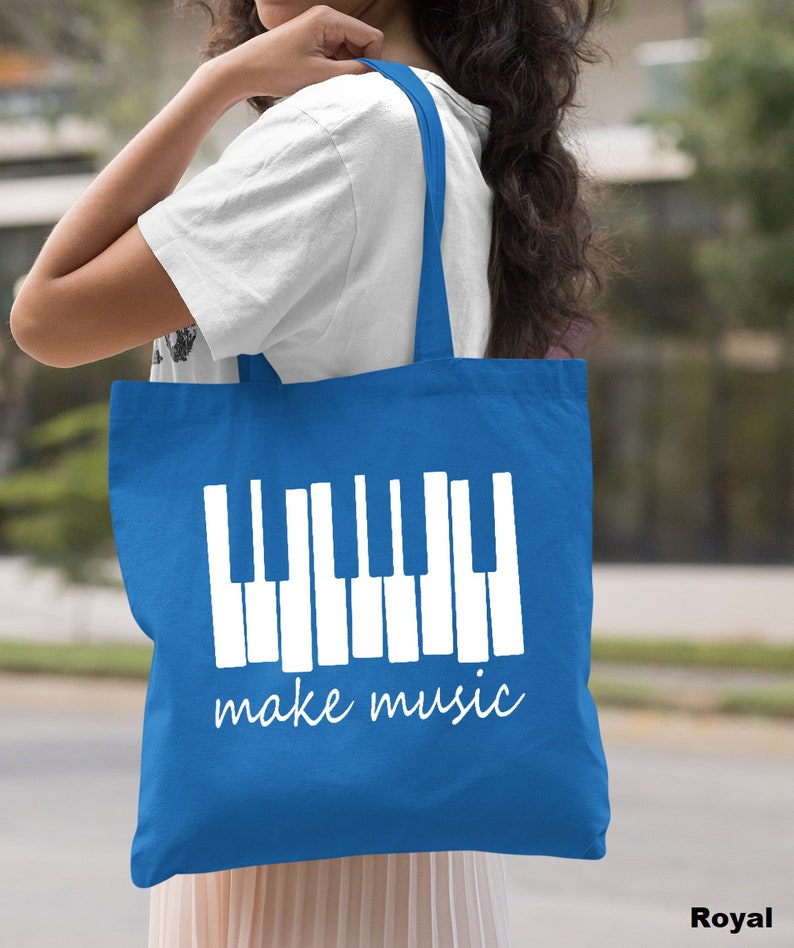 May include: A royal blue tote bag with white handles and a white graphic of a piano keyboard with the text "make music".