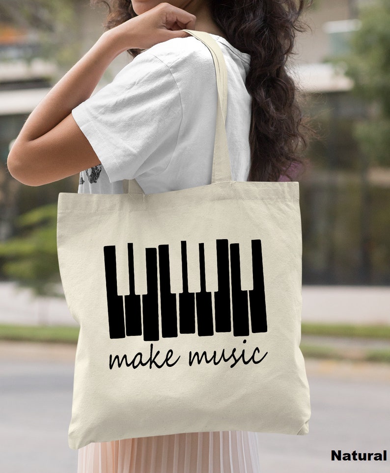 May include: A natural canvas tote bag with black piano keys and the text "make music".