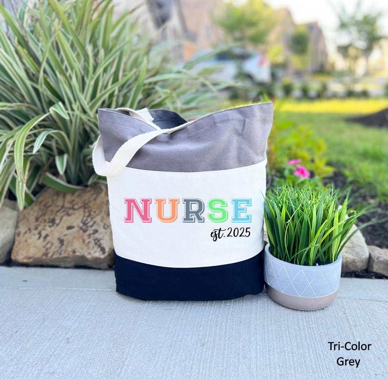 May include: A grey and black tote bag with the word "NURSE" in rainbow colours and the text "est. 2025".