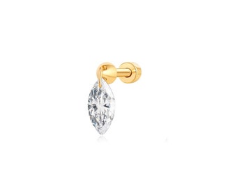 May include: A gold earring with a marquise-shaped clear crystal dangling from it.