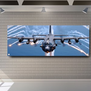 Könnte beinhalten: Ein graues Militärflugzeug fliegt am Himmel mit Rauchspuren, die aus dem Heck des Flugzeugs kommen.