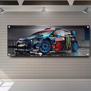 Può includere: Un'auto da rally blu, nera e arancione con i loghi Monster Energy e DC Shoes. L'auto è in un garage con un pavimento riflettente.