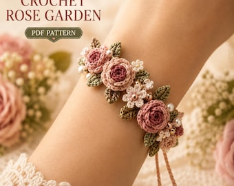 May include: A crochet bracelet featuring pink roses, small white flowers, and green leaves, accented with white and gold beads. The bracelet has two dangling strings with gold beads at the ends. Text in the image reads: CROCHET ROSE GARDEN PDF PATTERN.