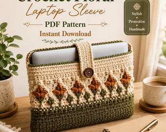 May include: A crochet laptop sleeve featuring a cream-coloured top section with a row of orange floral motifs and green stems, and a solid dark green bottom section. The sleeve has a central tab closure with a brown button and contains text.