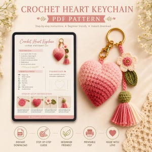May include: A digital tablet displays a PDF pattern for a crochet heart keychain, featuring text, diagrams, and instructions. Beside it, a physical crochet heart keychain with an ombre pink heart, a small flower, and a pink tassel hangs from a gold ring.