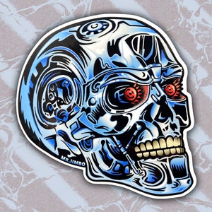 Może przedstawiać: Niebieska i srebrna czaszka z czerwonymi, świecącymi oczami. Czaszka jest ozdobiona mechanicznymi częściami, a w lewym dolnym rogu widoczny jest napis "MR. JIMBO".