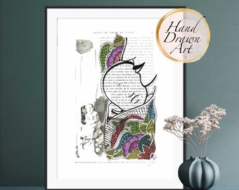 May include: A hand-drawn illustration of a woman's face with colorful floral patterns on a vintage book page. The text on the page is in French. The image is framed and displayed on a shelf.