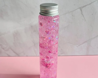 Frasco sensorial rosa com rosto feliz: frasco com glitter calmante, alívio da ansiedade