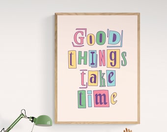 May include: A framed print with a light pink background and the text "Good things take time" in colorful, cut-out letters.
