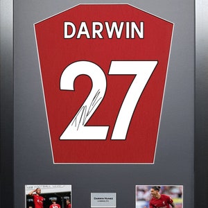 May include: A framed red and white football shirt with the name "DARWIN" and the number "27" on the front. The shirt is signed by the player. There are two smaller photos of the player in the frame.