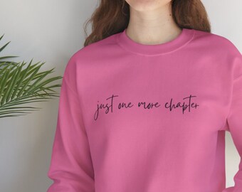 May include: Pink sweatshirt with the text "just one more chapter" in black script.