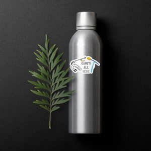 May include: A silver water bottle with a sticker that says "GANG'S ALL HERE" and features a microphone, a fishing rod, a toothbrush, and a pair of headphones.