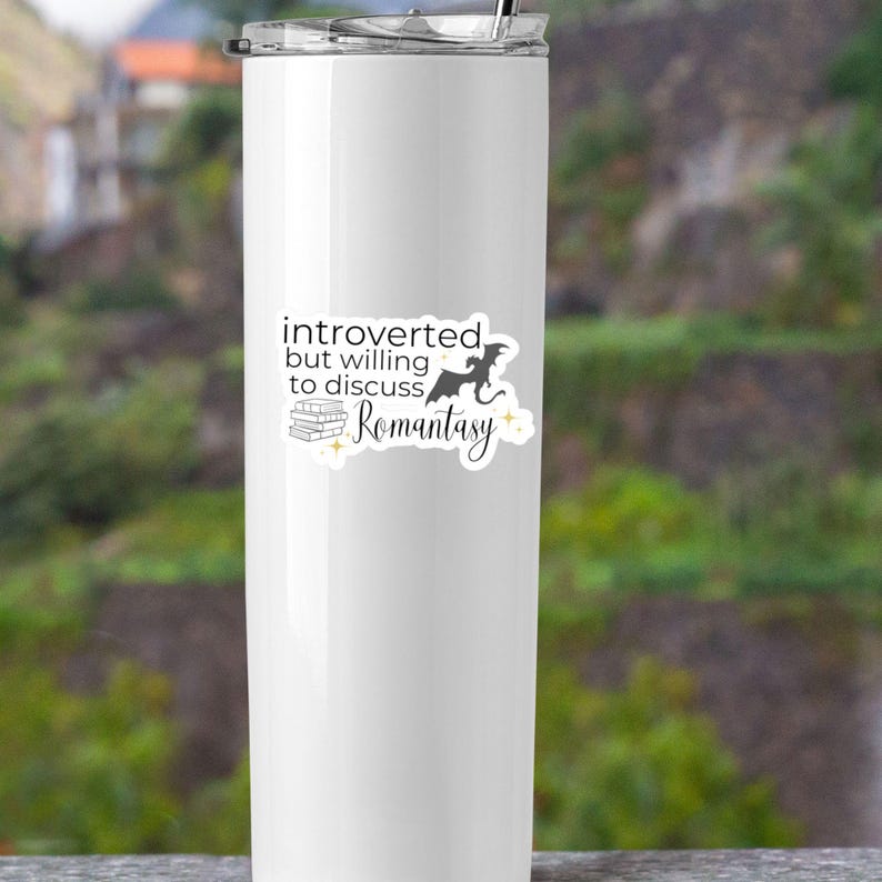 May include: White stainless steel tumbler with a black and white sticker that says "introverted but willing to discuss Romantasy". The sticker also features a black silhouette of a dragon and a stack of books.