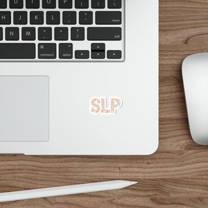 Pu&ograve; includere: Un adesivo con le lettere "SLP" in un motivo floreale con fiori rosa, arancioni e blu. L'adesivo &egrave; su un laptop bianco.