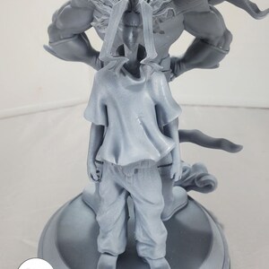K&ouml;nnte beinhalten: Eine graue 3D-gedruckte Figur von zwei Charakteren aus einem beliebten Anime. Der gr&ouml;&szlig;ere Charakter steht mit dem R&uuml;cken zum Betrachter, w&auml;hrend der kleinere Charakter vor ihm steht. Der kleinere Charakter tr&auml;gt ein T-Shirt und eine Hose.
