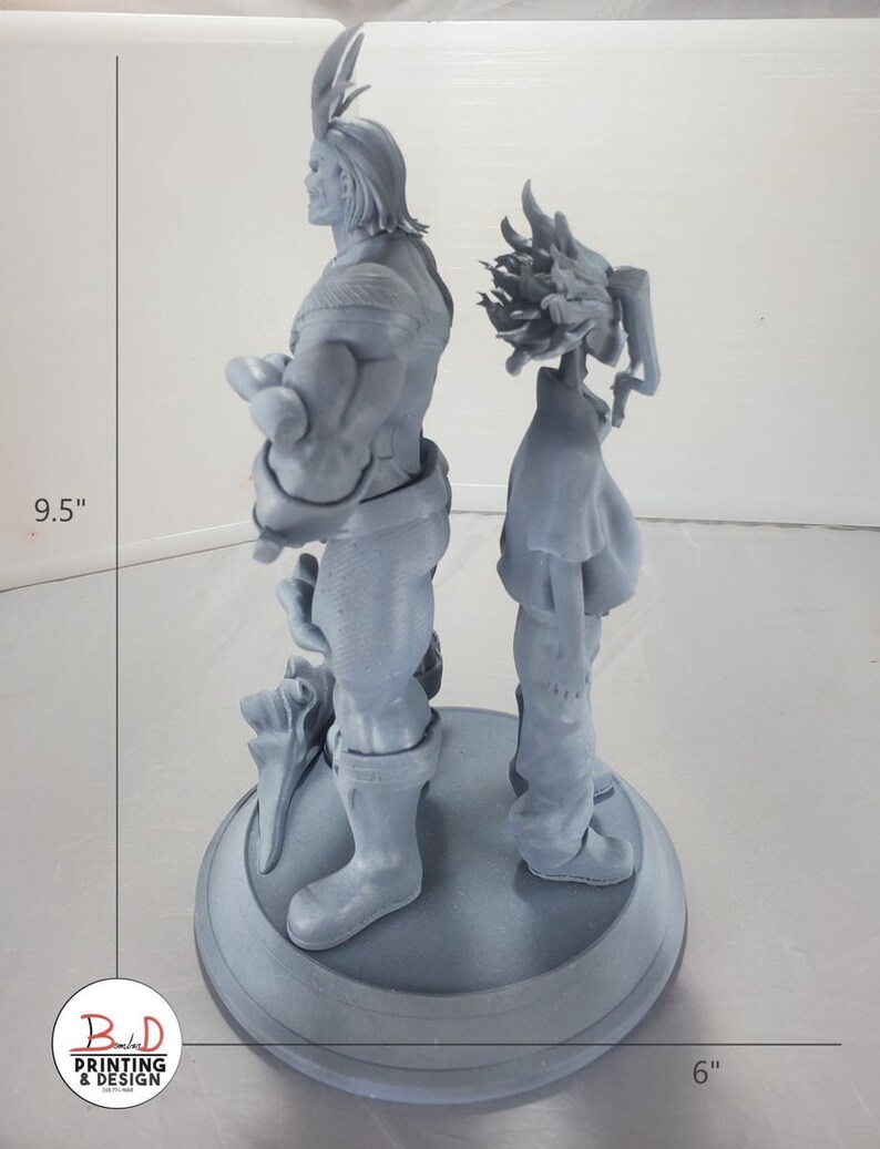 K&ouml;nnte beinhalten: Eine 3D-gedruckte graue Figur von zwei Charakteren, die auf einem runden Sockel stehen. Der Charakter links ist eine muskul&ouml;se Figur mit H&ouml;rnern und einem Umhang. Der Charakter rechts ist eine kleinere Figur mit stacheligem Haar. Der Sockel hat einen Durchmesser von 15,2 cm und die Figur ist 24,1 cm hoch.