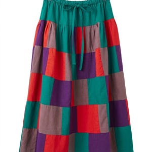 May include: A midi-length skirt featuring a patchwork design of rectangular panels in solid teal, deep purple, red, and muted brown. The skirt has an elasticized waistband with a matching teal drawstring tie and hangs from a clear plastic hanger.